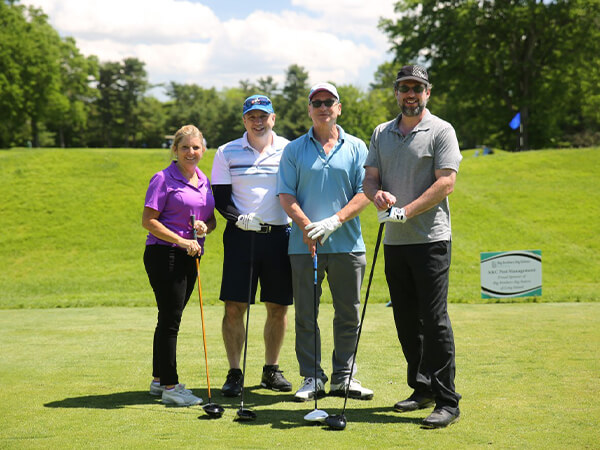 A group of golfers posing at the tee