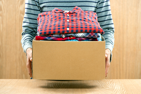 Man holding box of clothes
