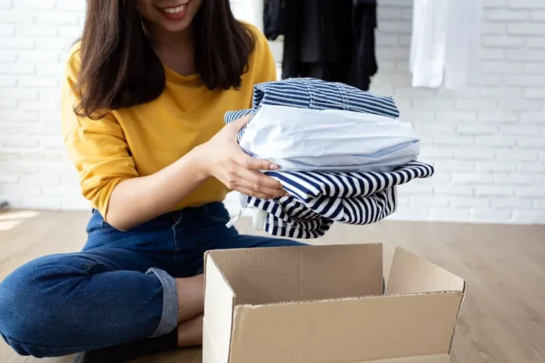 A women packing some clothes for donation
